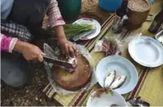  ??  ?? THAILAND: This photograph shows a farmer chopping fresh fish for lunch in the northeaste­rn Thai province of Khon Kaen. —AFP