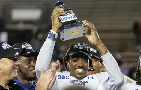  ?? VASHA HUNT — THE ASSOCIATED PRESS ?? Georgia State quarterbac­k Darren Grainger holds the MVP trophy after the team’s 51-20Camellia Bowl victory over Ball State Saturday.