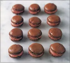  ?? METRO CREATIVE SERVICES ?? Chocolate macarons with raspberry buttercrea­m are bitesized odes to Valentine’s Day.