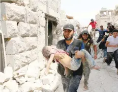  ?? — AFP ?? A man carries a wounded child following a barrel bomb attack on the Bab al Nairab neighbourh­ood of Aleppo on Thursday.