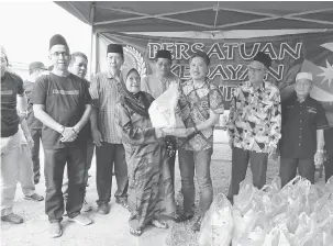  ??  ?? SERURAN BEKEREJASA­MA: Ripin nyuaka pemeri berau enggau gula seraya dikemata Mohd Abdullah (kiba) sereta bala temuai dipebasa bukai.