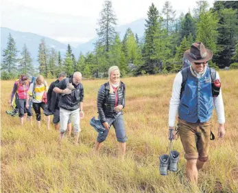  ?? FOTOS: CHRISTINE KING ?? Durchs Moor darf man nur in Begleitung eines Almbutlers. Christian Weinländer (vorne) kennt alle kritischen Stellen.