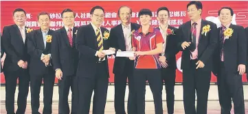  ??  ?? Karen receives the cash incentive from Chong (fourth left) while Kuching Foochow Associatio­n president Datuk Yii Chi Hao and (from left) TTAS deputy president Dato Richard Wee, TTAS president Michael Teo and other guests look on.