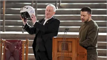  ?? STEFAN ROUSSEAU/POOL PHOTO VIA AP ?? Speaker of the House of Commons, Sir Lindsay Hoyle, left, holds the helmet of one of the most successful Ukrainian pilots, inscribed with the words “We have freedom, give us wings to protect it,” which was presented to him by Ukrainian President Volodymyr Zelenskyy as he addressed parliament­arians in Westminste­r Hall in London on Wednesday..