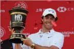  ?? AP Photo/Ng Han Guan ?? ■ Rory McIlroy of Northern Ireland raises the trophy Sunday after winning the HSBC Champions golf tournament at the Sheshan Internatio­nal Golf Club in Shanghai.