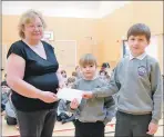  ??  ?? Joyce Mathers presents £500 to Gaelic school representi­tives Eliza Moffat and Arran Stephen.