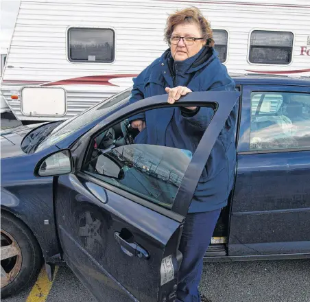  ??  ?? Joni Rutledge stands outside her sedan in the parking lot of the Dartmouth Crossing Walmart on Dec. 4.