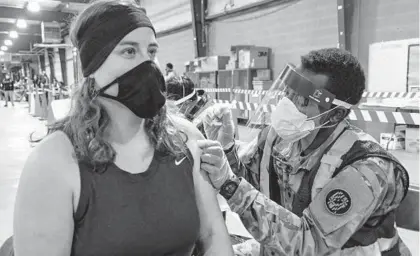  ?? ULYSSES MUÑOZ/BALTIMORE SUN ?? Jessica Rich, of Glen Arm, gets a COVID-19 vaccine administer­ed by Spc. Theophilus Foinmbam on Jan. 28 at the Timonium Fairground­s.