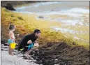  ?? Eduardo Verdugo ?? The Associated Press Tourists gaze at a shore covered in sargassum Sunday in Bahia La Media Luna in Quintana Roo state, Mexico.