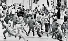  ??  ?? Anti-apartheid activists running away from a police charge during a demonstrat­ion in 1976 in Cape Town. AFP