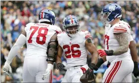  ?? JOHN FROSCHAUER — THE ASSOCIATED PRESS ?? New York Giants running back Saquon Barkley (26) celebrates with offensive tackle Andrew Thomas (78) and guard Jack Anderson after scoring a touchdown against the Seattle Seahawks during the first half of an NFL football game in Seattle on Sunday, Oct. 30, 2022.