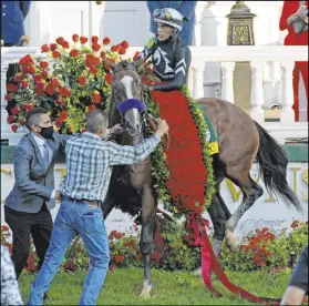  ?? Jeff Roberson The Associated Press ?? Jockey John Velazquez attempts to control Authentic in the winners’ circle after winning the Kentucky Derby.