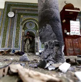  ?? REUTERS ?? A HOUTHI militant scours the ruins of the al-Balili mosque after two suicide bombings hit the religious center in Yemen’s capital Sanaa. At least 10 people were reported killed and 36 wounded in the attack.