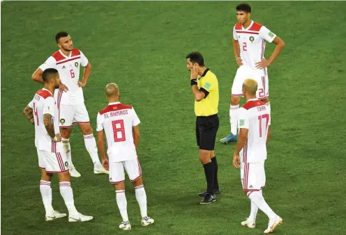  ?? Foto: AFP/Ozan Kose ?? Immer mit einem Ohr beim VAR: Die WM-Schiedsric­hter, wie der Usbeke Ravshan Irmatov zwischen Marokkos Fußballern, bekommen viel Lob.