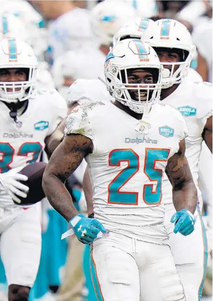  ?? LYNNE SLADKY/AP ?? Dolphins cornerback Xavien Howard (25) celebrates with teammates against the Jets this season.