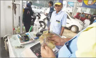  ??  ?? An Indian customer pays for fuel with old 500 rupee notes at a petrol station in New Delhi on Dec 2, the last day on which the old currency can be used to purchase fuel. Anger mounted in India over the scrapping of high denominati­on notes as the government said old notes would no longer be accepted at petrol pumps after Dec 2, worseninga­n unpreceden­ted cash crunch. (AFP)