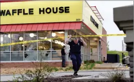  ?? ASSOCIATED PRESS ?? LAW ENFORCEMEN­T OFFICIALS work the scene of a fatal shooting at a Waffle House in the Antioch neighborho­od of Nashville on Sunday.