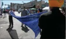  ?? KEVIN TUSTIN – DIGITAL FIRST MEDIA ?? Blue fabric is first stretched out a bit before being used for wrapping turbans, common headdress for Sikh men. The Upper Darby Multicultu­ral Commission had a table at the internatio­nal festival wrapping turbans for festival goers.