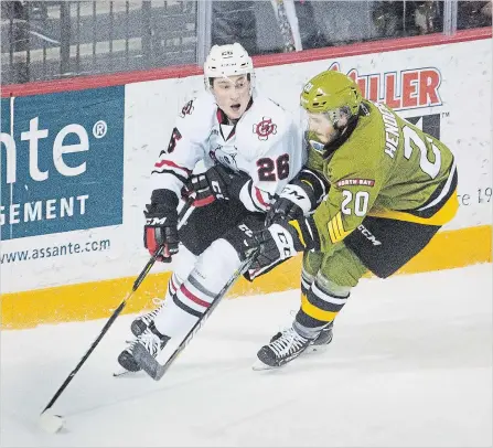  ?? BOB TYMCZYSZYN THE ST. CATHARINES STANDARD ?? North Bay’s Braden Henderson (20) stick checks Niagara’s Philip Tomasino (26) in Ontario Hockey League action Friday night at Meridian Centre in St. Catharines.