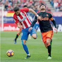  ?? Reuters ?? Atletico Madrid’s Yannick Ferreira-Carrasco and Valencia’s Enzo Perez vie for the ball. —