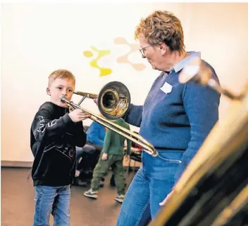  ?? FOTO: ANNE ORTHEN ?? Stephanie Spee, Lehrerin für Blasblechi­nstrumente zeigt Moritz in der Musikschul­e Strümp, wie er die ersten Töne aus der Posaune bekommt.