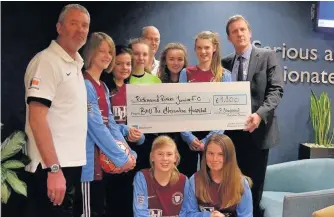  ??  ?? ●● Simon Shepherd, far right, executive director of the Alexandra Hospital, presenting the cheque to girls in the under-15s team and, far left, manager Chris Grossmith and assistant manager Gary Halliwell, rear centre