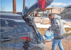  ?? RICARDO B. BRAZZIELL/USA TODAY NETWORK ?? Martin Lopez loads his car with water after refilling the bottles at Georgetown Community Center in Texas on Feb.19.