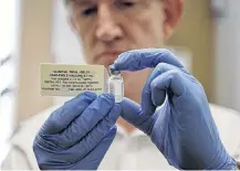  ??  ?? Professor Adrian Hill, Director of the Jenner Institute, and Chief Investigat­or of the trials, holds a phial containing the Ebola vaccine at the Oxford Vaccine Group Centre for Clinical Vaccinolog­y and Tropical Medicine (CCVTM) in Oxford, southern England on Sept. 17, 2014.