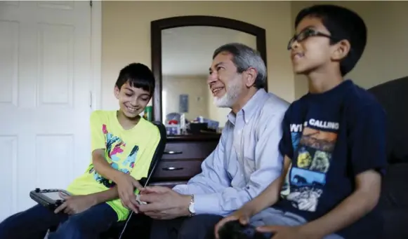  ?? MARTA IWANEK PHOTOS/TORONTO STAR ?? Mustafa Merchant, 10, and Ibrahim Merchant, 7, play video games with their grandfathe­r Mohammed Jalaluddin.