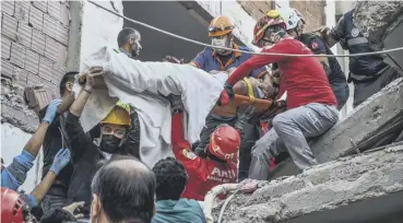  ??  ?? 0 Rescuers and local volunteers carry a wounded victim on a stretcher from a collapsed building