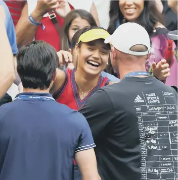  ??  ?? Emma Raducanu celebrates her US Open title success with coach Andrew Richardson (cap). Photo: Getty Images.