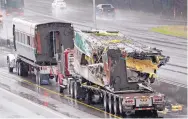  ?? ELAINE THOMPSON/ASSOCIATED PRESS ?? Two damaged train cars sit on flatbed trailers Tuesday after being taken from the scene of Monday’s Amtrak train crash onto I-5 in DuPont, Washington.