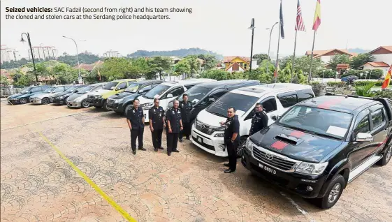  ??  ?? Seized vehicles: SAC Fadzil (second from right) and his team showing the cloned and stolen cars at the Serdang police headquarte­rs.