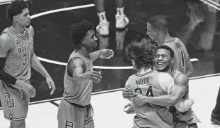  ?? Kathy Batten / Associated Press ?? Baylor players bask in the glory of Tuesday’s 94-89 overtime win over No. 6 West Virginia that clinched the No. 3 Bears’ first Big 12 regular-season championsh­ip.