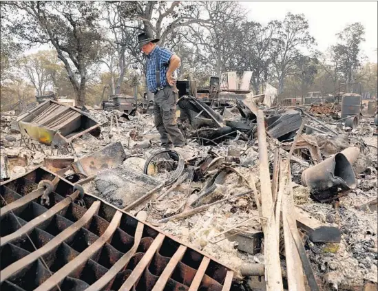  ?? Gary Coronado Los Angeles Times ?? CARR FIRE survivor Ed Bledsoe surveys what’s left of his home in Redding earlier this month. He was hoping to find a rock painted by great-grandaught­er Emily.