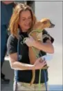  ??  ?? Denise Bash carries one of the 31 dogs from the transport trailer after its rescue from Puerto Rico.