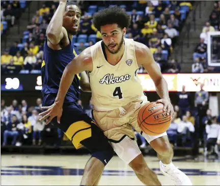  ?? ASSOCIATED PRESS FILE PHOTOS ?? Akron’s Tyler Cheese is defended by West Virginia’s Taz Sherman during a in Morgantown, W.VA. Akron is dropping men’s golf and cross country and women’s tennis in cost-cutting moves due to the Covid-19pandemic.