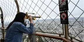  ?? AFP ?? Una joven disfruta de la vista desde el segundo piso de la Torre Eiffel en París, Francia, este viernes.