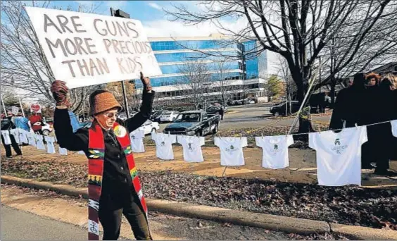  ?? JONATHAN ERNST / REUTERS ?? Dos mundos. Protesta contra la Asociación Nacional del Rifle en el cuarto aniversari­o de la matanza de Sandy Hoo, que Tracy considera irreal