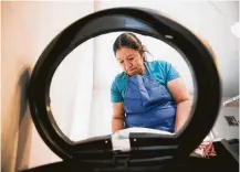  ?? Marie D. De Jesús / Staff photograph­er ?? Activist and domestic worker Julia De Leon puts a new bag in a trash can while cleaning a client’s home in Houston.