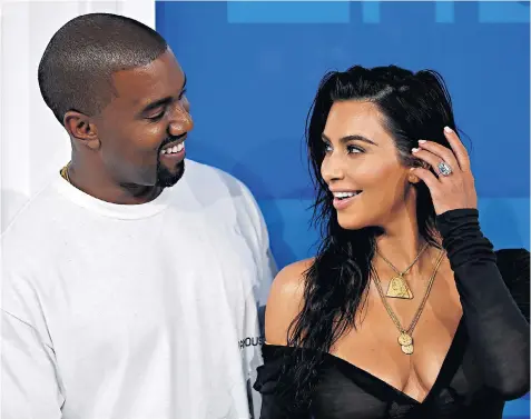  ??  ?? Bling: Kim Kardashian, wearing her 20ct diamond ring, with husband Kanye West