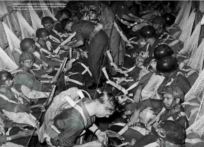  ??  ?? SAS troopers wait before ‘tree parachutin­g’ (a technique of low-level jumping) onto communist insurgents in the Malayan jungle on 29 October 1959