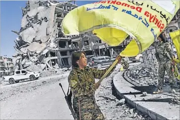  ?? Bulent Kilic AFP/Getty Images ?? a commander with the opposition Syrian Democratic Forces, celebrates in Raqqah. Islamic State had overrun the city in 2014 and forced residents into submission with its reign of terror.