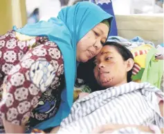  ?? — Reuters photo ?? A girl, who was affected by the tsunami, is hugged by her mother as she is treated at a hospital in Kalianda in South Lampung, Indonesia, in this photo taken by Antara Foto.