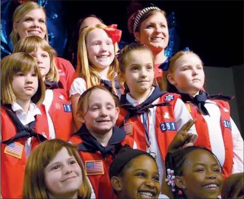  ?? Special to the Democrat-Gazette ?? American Heritage Girls unit leaders (top left and right) stand with a group in the Tenderhear­t level for girls ages 6 to 9. The Kansas City archdioces­e singled out the 22-year-old nonprofit as an alternativ­e to Girl Scouts in May, and the faith-based...