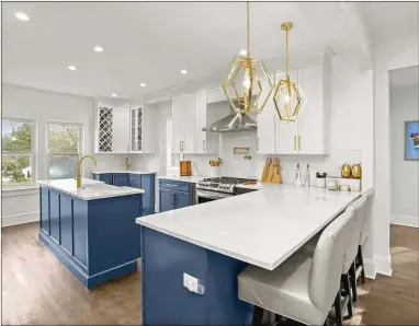  ?? Contribute­d by Coldwell Banker Realty ?? Designed by the homeowners, the kitchen at 8 Scott Road has custom cabinets, stainless appliances, a wet bar, three ovens and island seating.