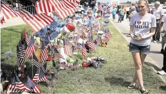  ?? Joe Raedle / Getty Images ?? Ashley Montgomery, whose husband is a Navy sailor, pays her respects Saturday at a memorial at the Armed Forces Career Center/National Guard Recruitmen­t Office in Chattanoog­a, Tenn. Five people were killed by Mohammod Youssuf Abdulazeez, 24, who later...