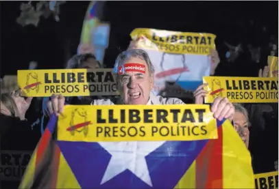  ?? Emilio Morenatti ?? The Associated Press Demonstrat­ors holding banners reading in Catalan “freedom for the political prisoners” gather Thursday outside the Catalonian Parliament in Barcelona to protest the decision of a judge to jail ex-members of the Catalan government.