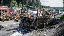  ?? Matthias Balk / dpa via Associated Press ?? Emergency crews survey the burned hulk of a bus that caught fire when in slammed into a truck near Muenchberg, Germany.