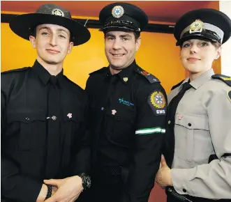  ?? IAN KUCERAK ?? Commercial vehicle enforcemen­t officer Aaron Smith, left, AHS EMS public education officer Alex Campbell and University of Alberta Protective Services peace officer Stephanie Hartwig model a new anti-bullying pin for law enforcemen­t and first...